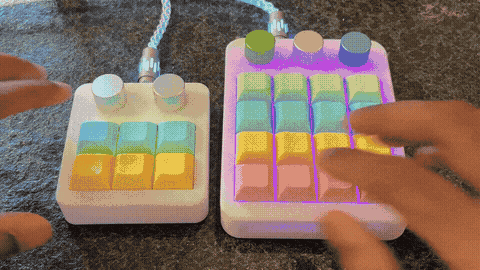 Two illuminated musical macropads with colorful keycaps and knobs